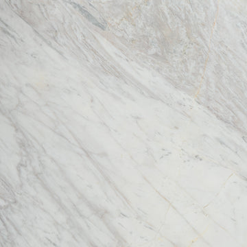 “FX‑149 Arctic Drift Marble” flexible panel by Dunya Home Design: a cool white marble ground shot through with soft, brush‑stroke swaths of pale gray‑blue and taupe that fan out diagonally, accented by fine, delicate hairline veins of warm gold.