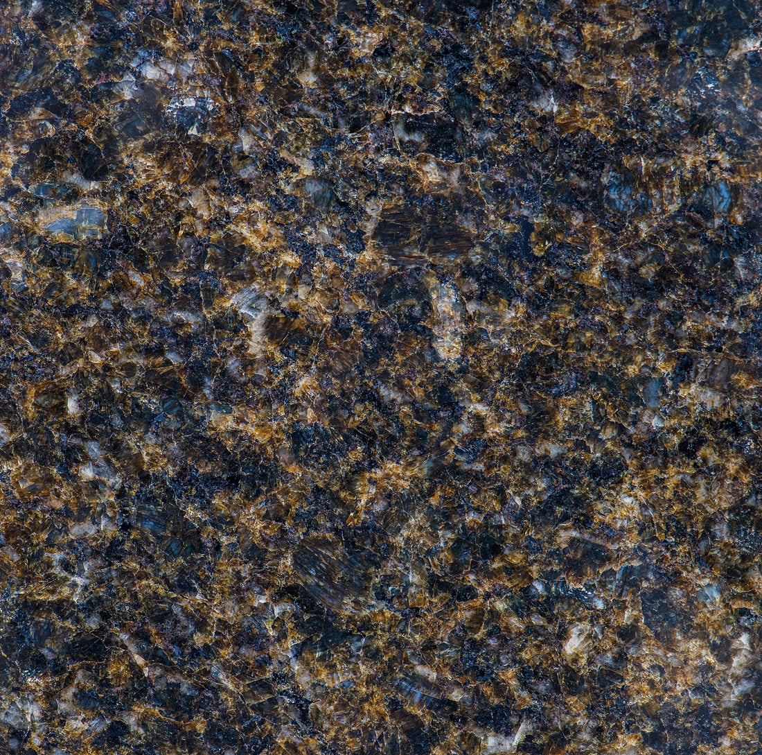 FX‑190 Midnight Ember Granite flexible granite panel showcasing a deep, near‑black background laced with iridescent midnight‑blue and smoky grey mineral flecks, interspersed with warm amber‑gold highlights that create a subtle, ember‑like glow, by Dunya Home Design.