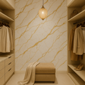 Modern walk-in closet with beige marble walls, shelves, and furniture.