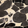 FX‑127 Midnight Pebble Marble flexible marble panel showcasing large irregular midnight-black pebble shapes embedded in a soft cream matrix with fine textural details, by Dunya Home Design.