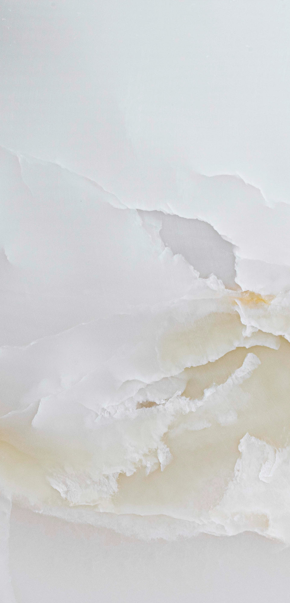 FX‑137 Golden Dawn Marble flexible marble panel showcasing luminous white and pale cream onyx layers with gentle golden-yellow highlights and soft translucent textures, by Dunya Home Design.