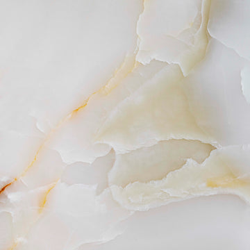 FX‑137 Golden Dawn Marble flexible marble panel showcasing luminous white and pale cream onyx layers with gentle golden-yellow highlights and soft translucent textures, by Dunya Home Design.