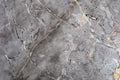 FX‑142 Iron Vein Marble flexible marble panel featuring a cool mid‑grey base streaked with bold white and rust‑orange veins, accented by fine iron‑speckled textures for an industrial yet elegant look, by Dunya Home Design.