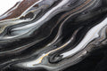 “FX‑152 Obsidian Flow Marble” flexible panel by Dunya Home Design: a dynamic, fluid pattern of swirling deep black base streaked with metallic silver and warm copper‑gold accents, creating a glossy, marble‑like surface with glittering, flowing veins.