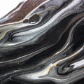 “FX‑152 Obsidian Flow Marble” flexible panel by Dunya Home Design: a dynamic, fluid pattern of swirling deep black base streaked with metallic silver and warm copper‑gold accents, creating a glossy, marble‑like surface with glittering, flowing veins.