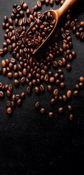 Marble mural of dark textured surface surrounded by coffee beans and espresso-making tools, evoking rich coffee tones