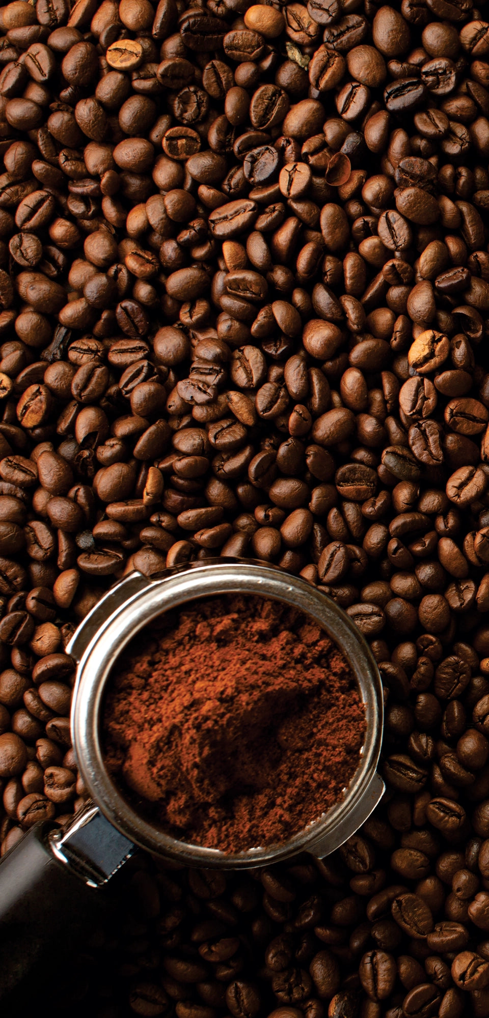 Marble mural of dark textured surface surrounded by coffee beans and espresso-making tools, evoking rich coffee tones